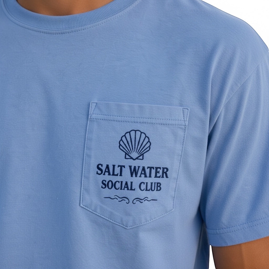 Press Society light blue cotton t-shirt with a navy seashell logo and "Salt Water Social Club" text on the chest pocket.