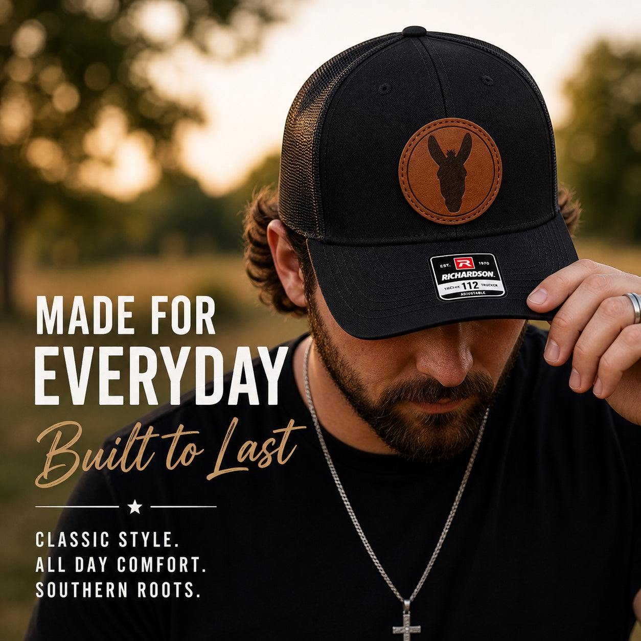 Press Society black trucker hat with a round brown leather patch featuring a mule silhouette. Adjustable mesh back.