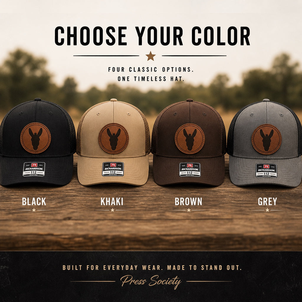 Press Society mule trucker hat available in black, khaki, brown, and grey with a circular leather patch featuring a mule silhouette.
